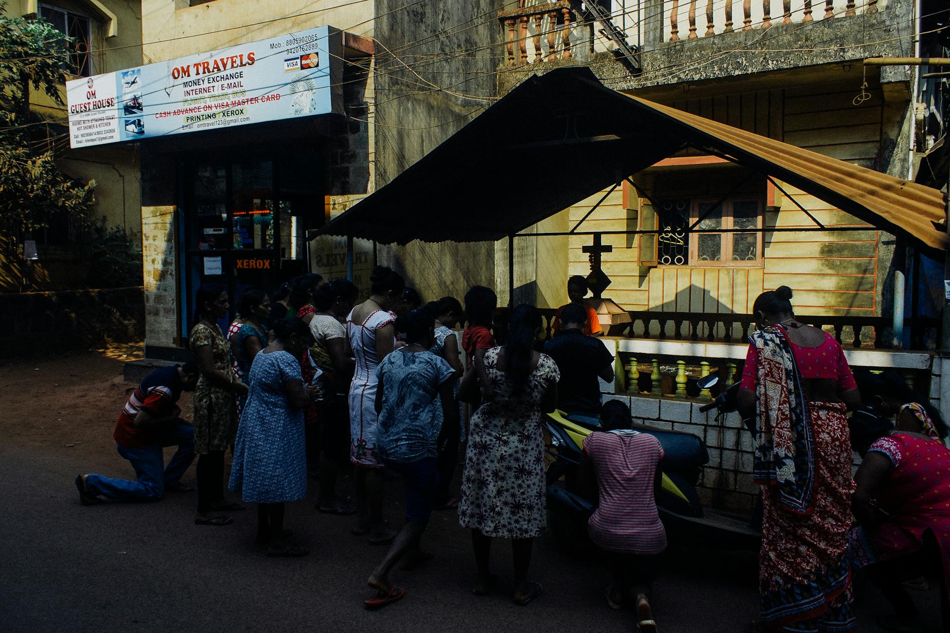 Crowd of ethnic people in indigenous traditional clothes gathering outside rural local church and praying