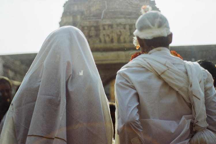 Unrecognizable Couple In White Traditional Clothes During Wedding Ceremony