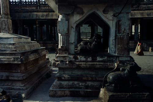 Weathered oriental stone sculptures statues and buildings located in medieval historic Hampi village in India