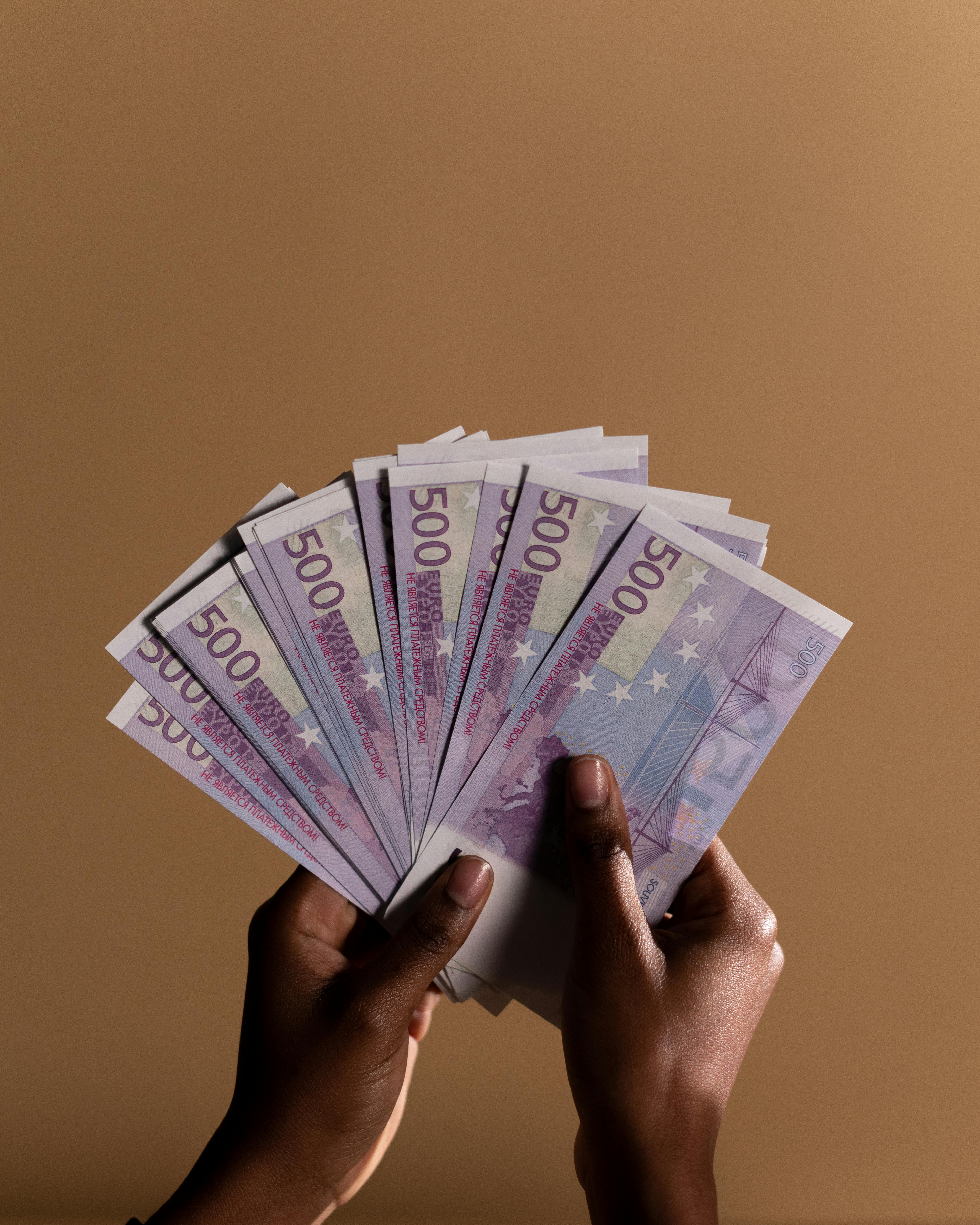 person holding fan of banknotes