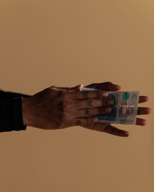 Free Close up of hands holding a banknote on a beige background. Stock Photo