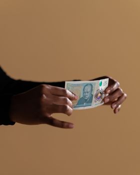 手拿五英镑钞票，强调中性背景下的现金和经济概念