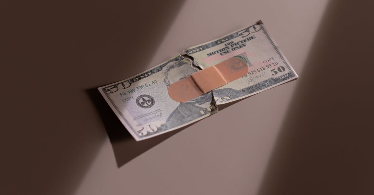 Photo by cottonbro studio A torn dollar bill patched with a bandage, symbolizing financial recovery.