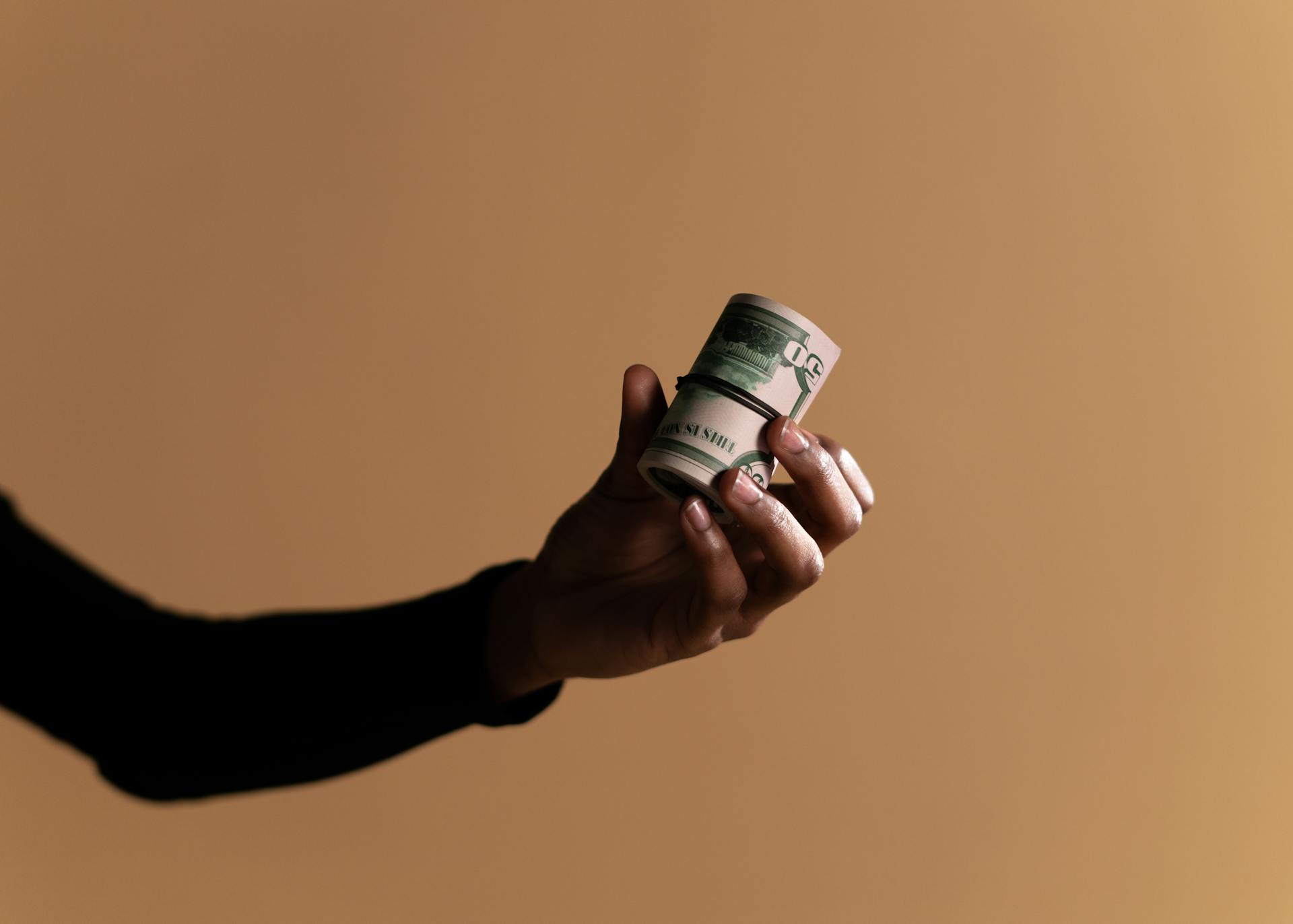 A Person Holding Rolled up Cash