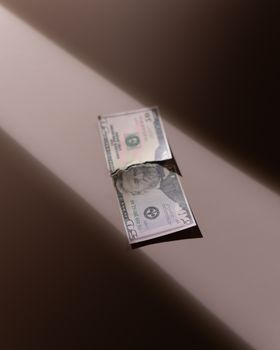 一张皱巴巴的5美元钞票在米色背景上，灯光柔和