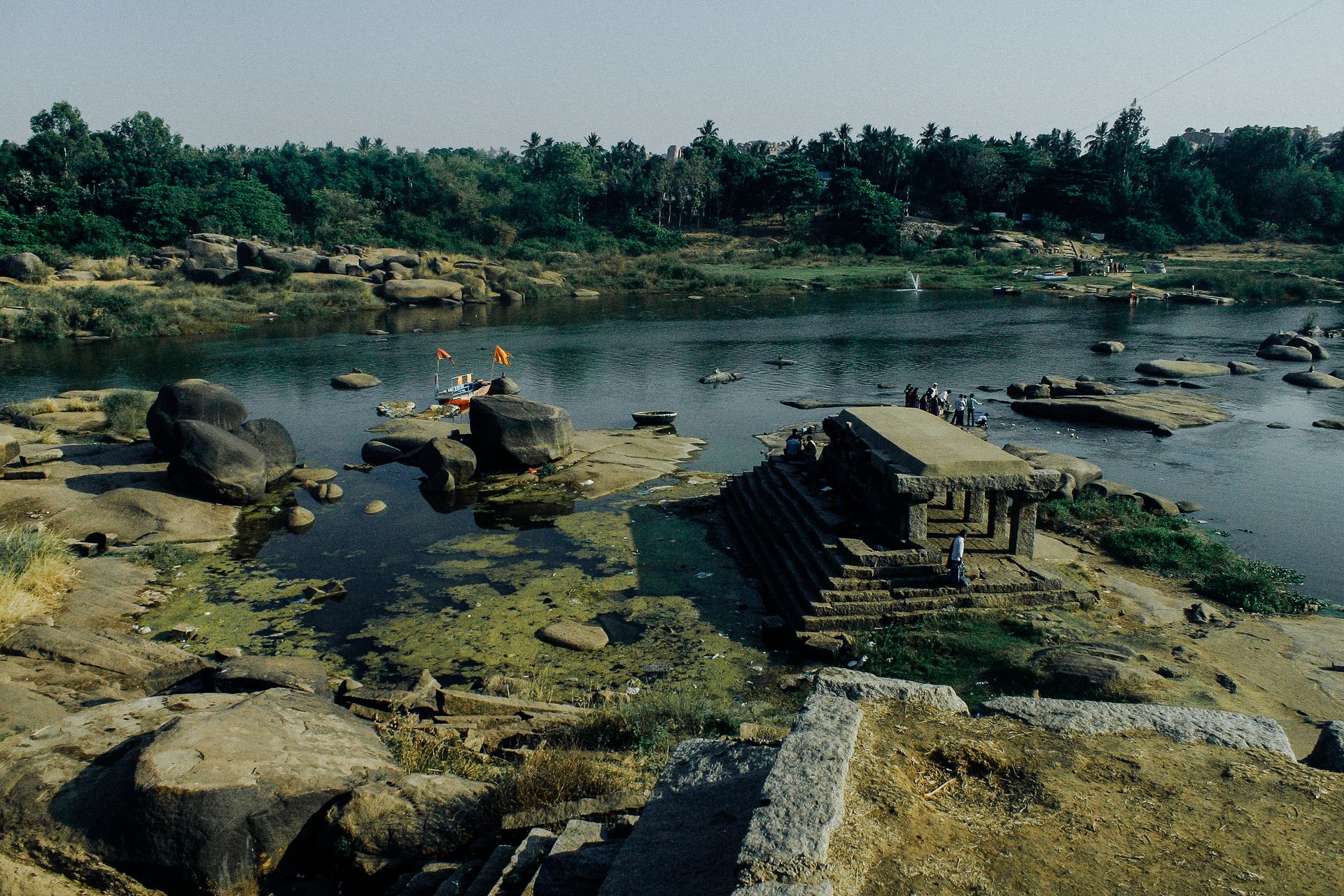 From above picturesque view of calm water of river with massive rocks and aged stone structure on bank