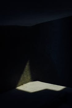 Mysterious and shadowy indoor corner illuminated by a subtle light beam.