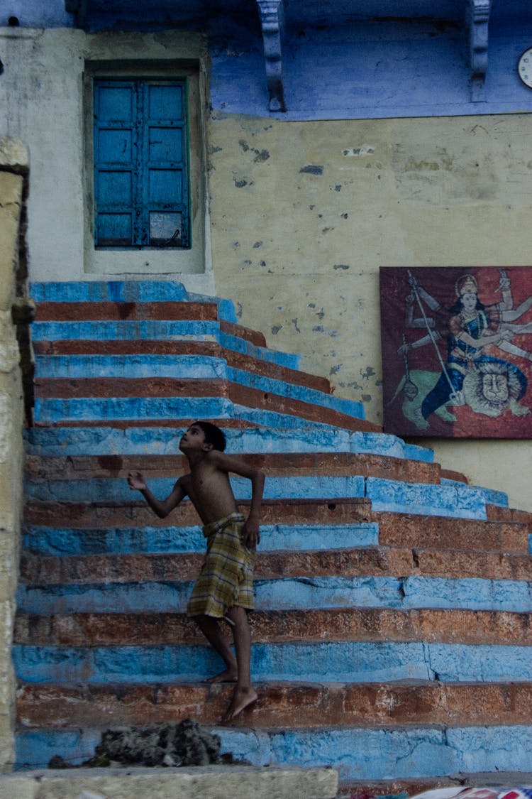 Ethnic Kid Jumping On Colored Stairway