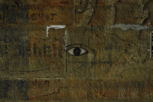 Eye picture painted on center shabby damaged concrete wall with scratches and stains
