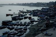 From above of wooden boats and native people near river in poor coastal settlement