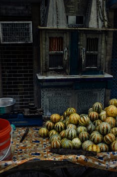 A vibrant market stall displaying ripe melons in a bustling urban environment.