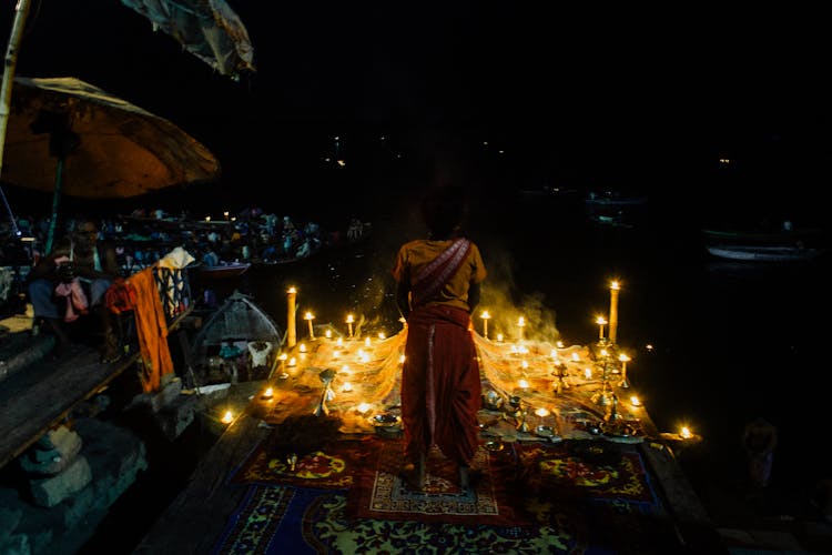 Indian Woman Praying With Burning Candles At Night