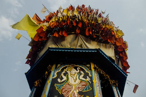 Low angle of colorful flags fluttering on wind on top of tower for traditional oriental celebration