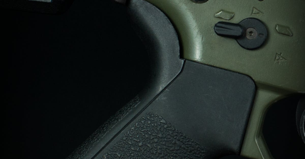 Photo by Dan Galvani Sommavilla Detailed close-up of a tactical firearm grip in low light, highlighting texture.