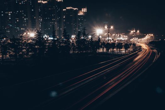 都市夜景中，有路上光的踪迹，被照亮的高层建筑和街灯