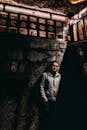 Man in Gray Zip Up Jacket Standing Near Concrete Wall