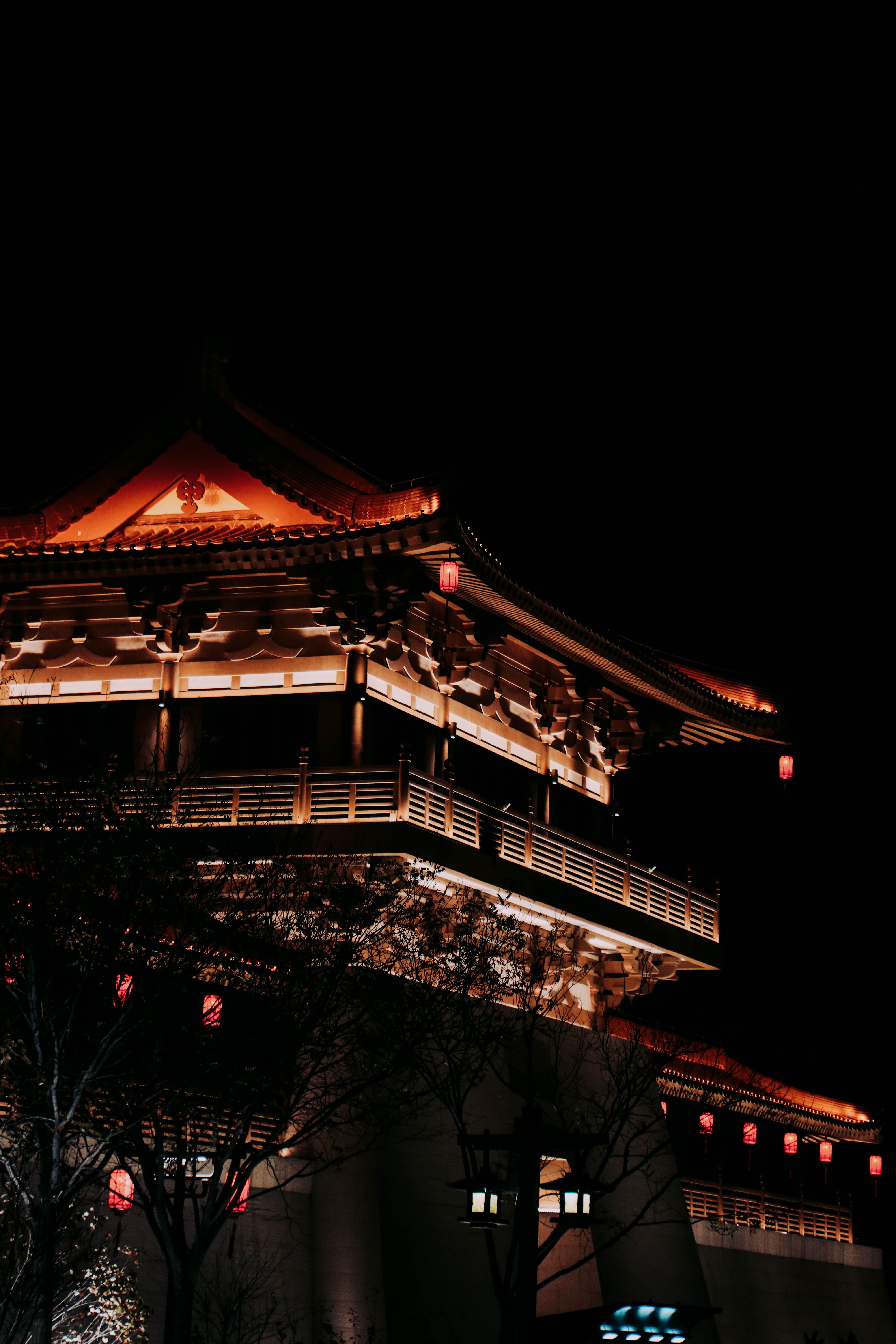 一座灯火通明的中国寺庙在夜间拍摄中，展示了其错综复杂的建筑细节