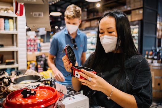 A couple wearing masks shops for kitchenware, exemplifying pandemic precautions.