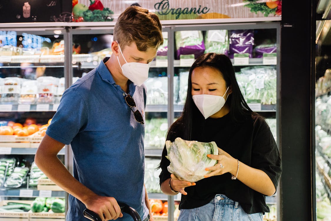 Free Пара с масками для лица, покупка свежих овощей Stock Photo
