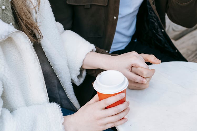 Crop Lady Holding Hands With Boyfriend While Drinking Takeaway Coffee