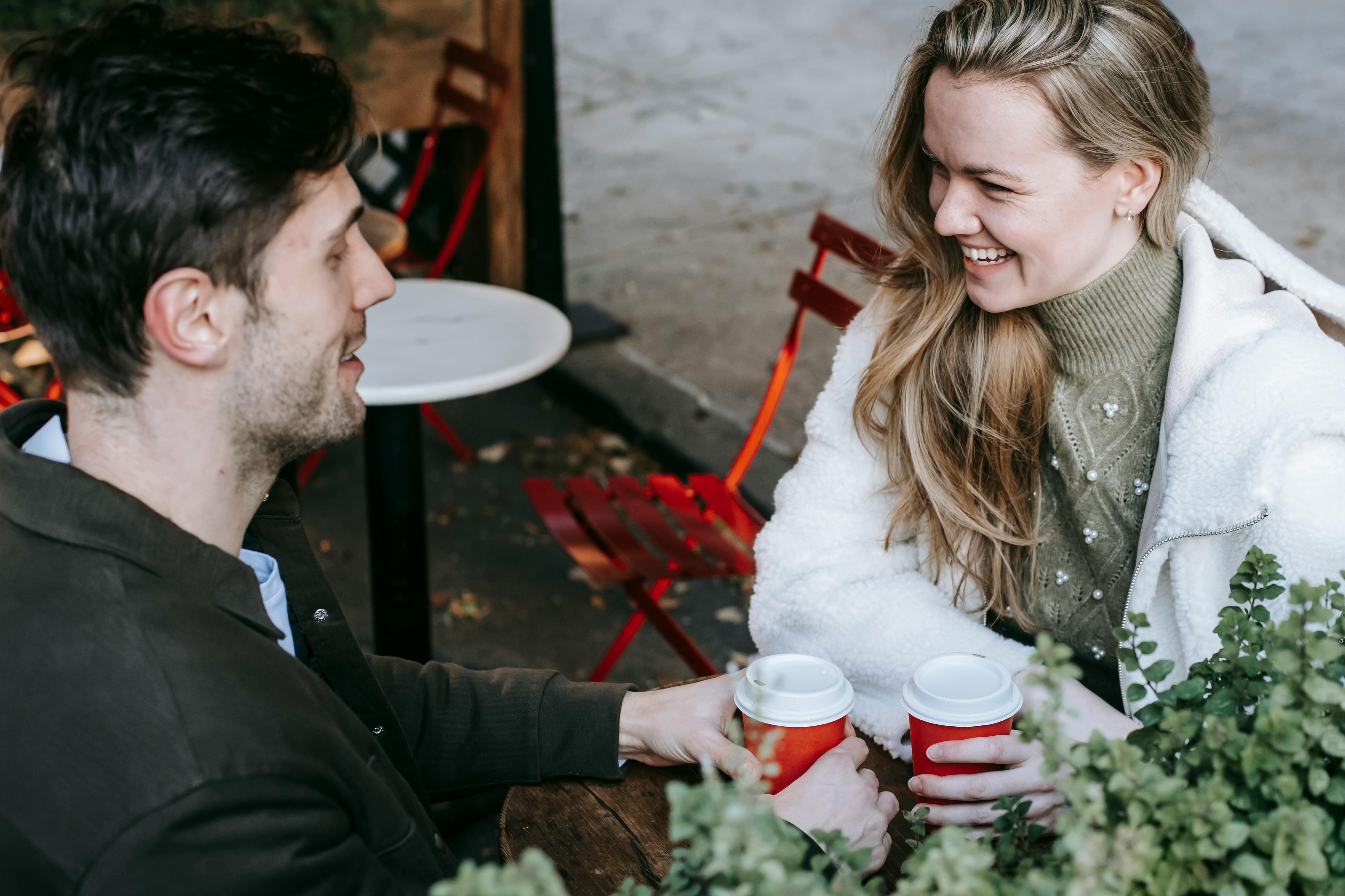 loving young couple laughing while spending free time together in cafe