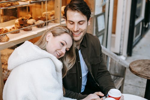 Free Happy woman with boyfriend enjoying hot beverage in bakery Stock Photo