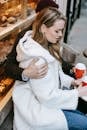 From above of young woman and man hugging and having hot drink in small cafeteria