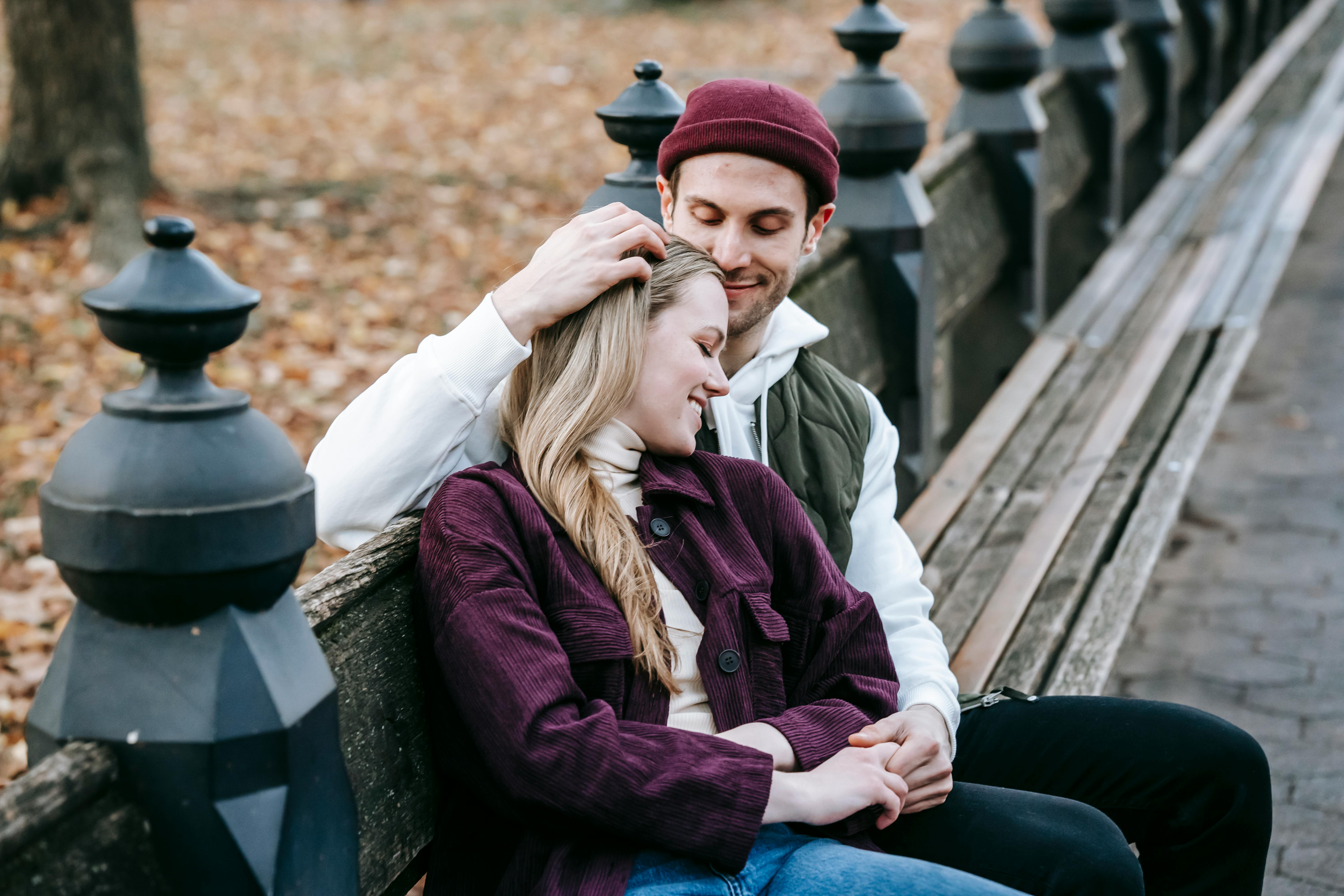 Premium Photo | Beautiful gourgeous couple sitting on a bench in autumn park