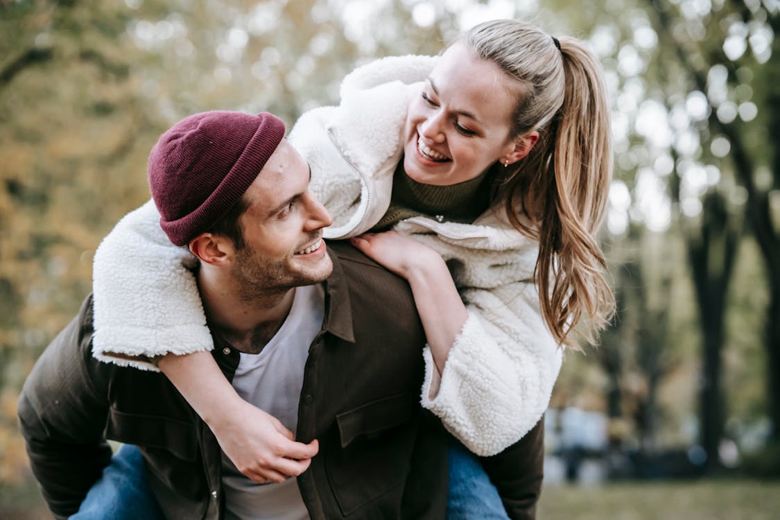 Free Joyful girlfriend embracing smiling boyfriend in hat Stock Photo