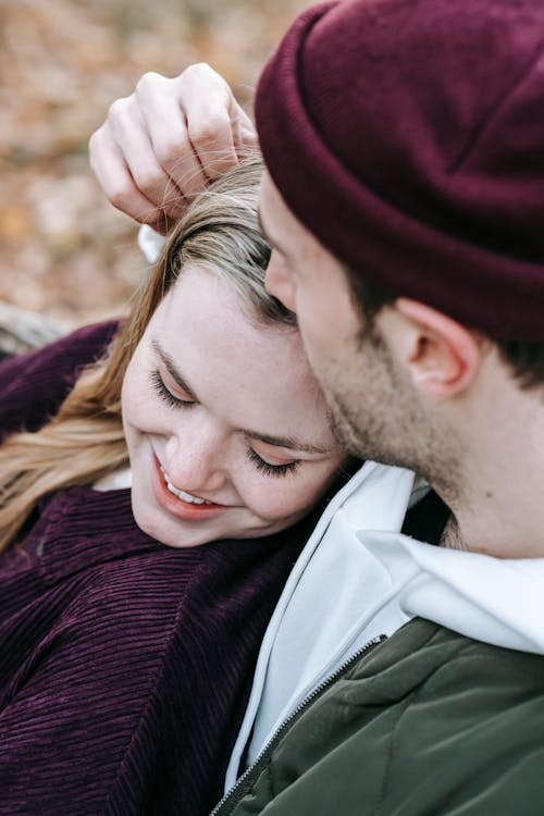 Homme En Pull En Tricot Marron Embrassant La Femme En Veste Blanche