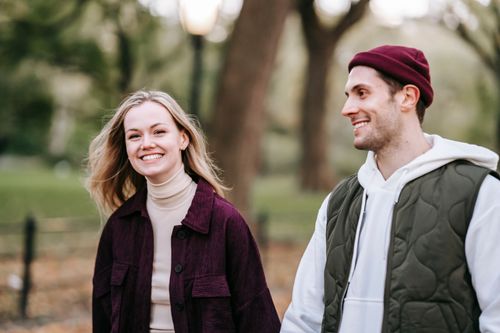 Free Happy loving young couple in casual warm clothes strolling in autumn park while having date Stock Photo