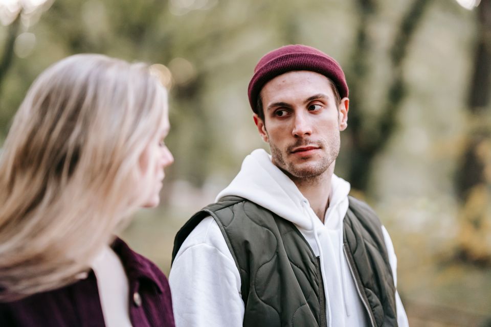 A young couple talking while walking through a park