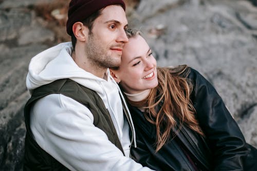 Crop dreamy couple in casual clothes embracing in daytime