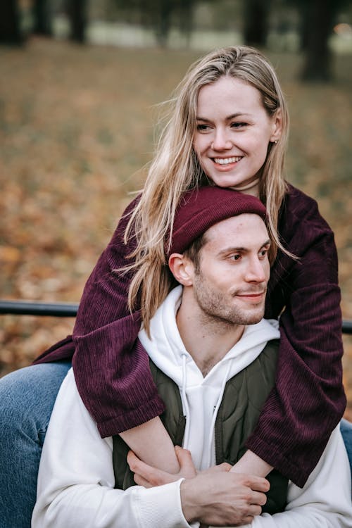 Smiling girlfriend embracing male partner in park