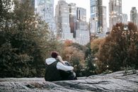 Romantic anonymous couple sitting on stony ground in city