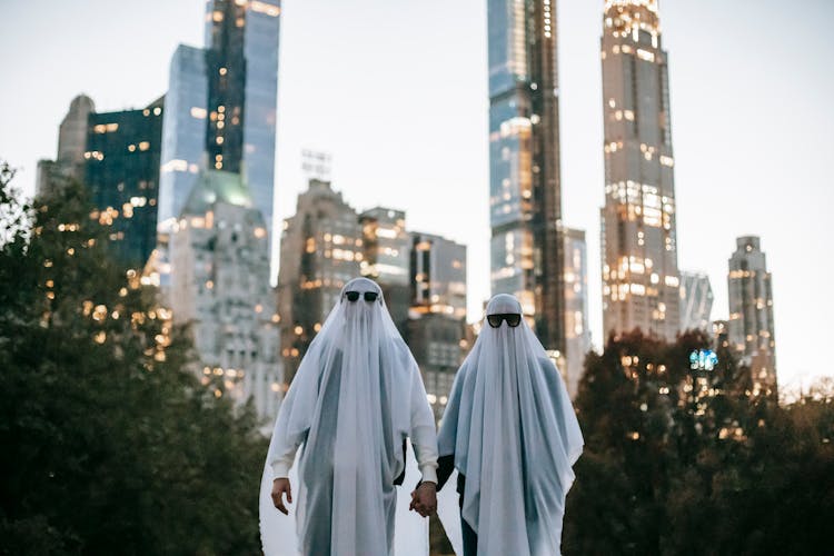 Unrecognizable Couple In Ghost Costume On Street