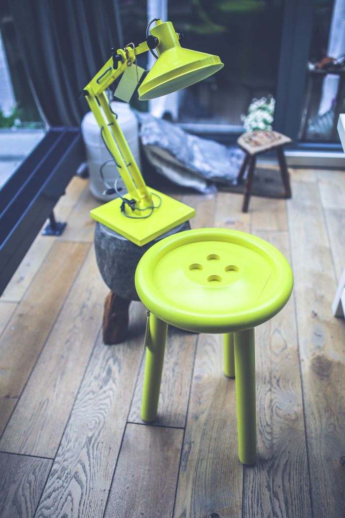 Bright chartreuse stool and lamp in a wood-floored room, photo by Karolina Grabowska on Pexels