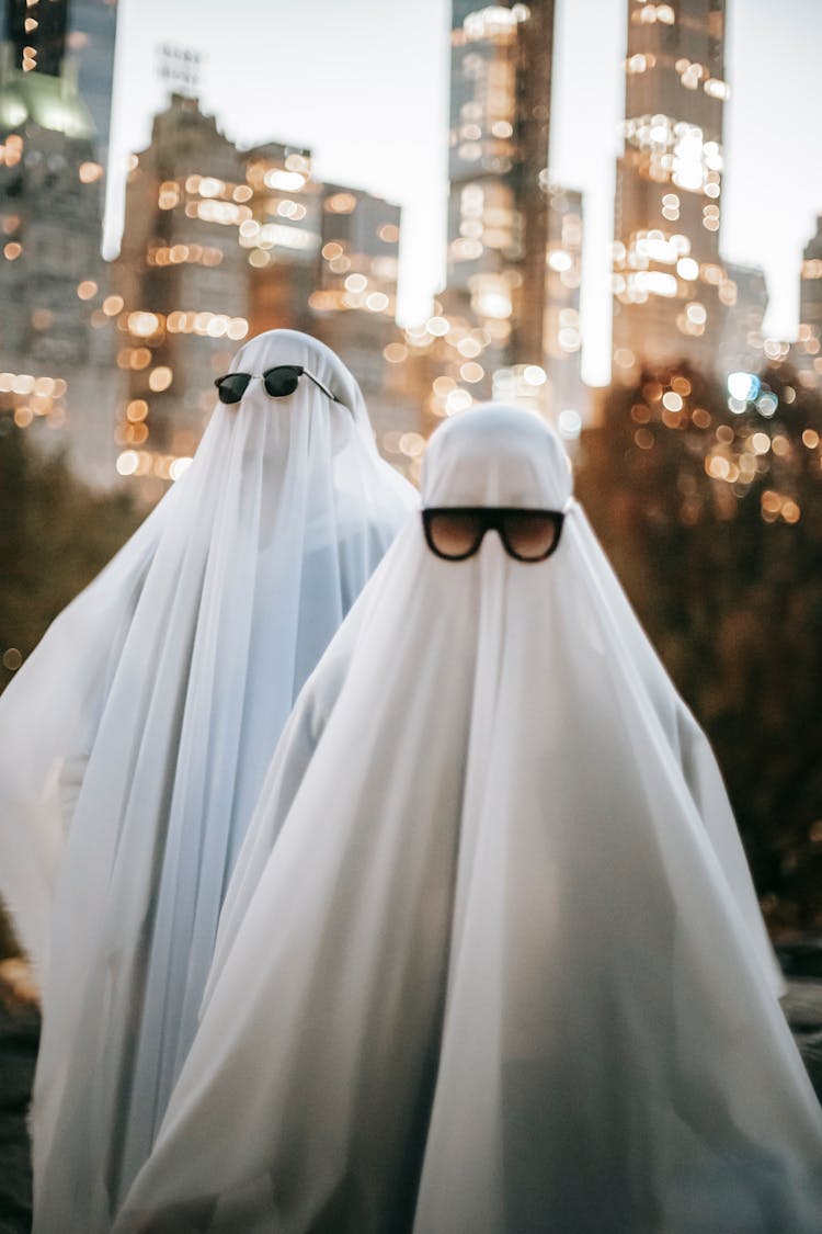 Unrecognizable Couple In Ghost Costumes Standing On Street