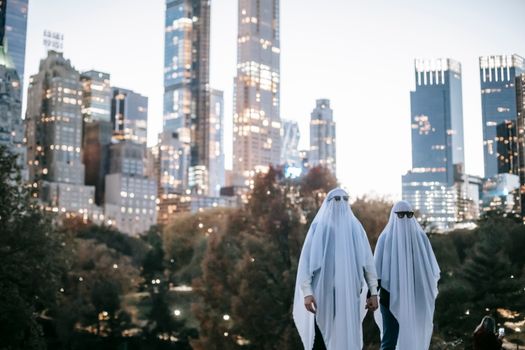 晚上，两个穿着幽灵服装、戴着太阳镜的人出现在城市公园里