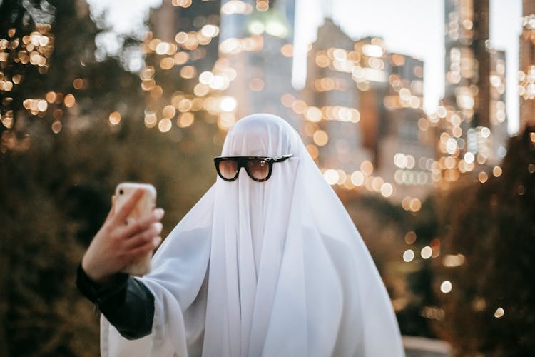 Unrecognizable Person In Ghost Costume Taking Selfie