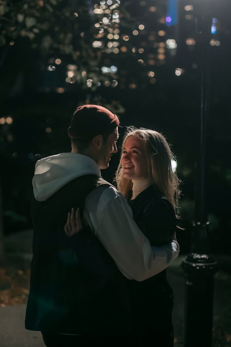 Cheerful Couple Hugging In Park In Darkness