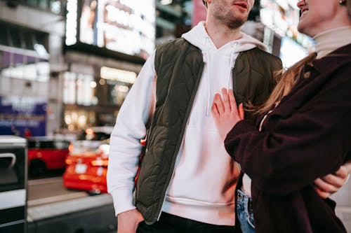 Crop couple hugging on street