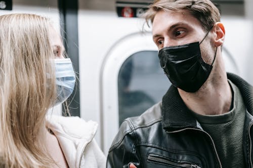 Couple in medical masks standing in subway