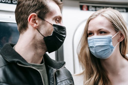 Anonymous couple in masks in subway train