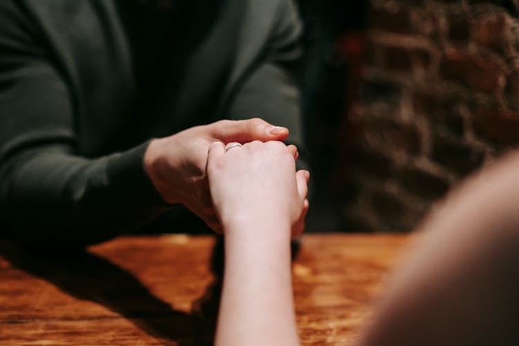 Unrecognizable Couple On Romantic Dinner With Engagement Ring In Cafe