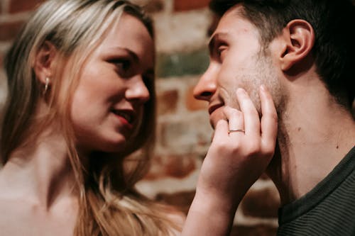Free Young smiling blond woman touching face of boyfriend while spending together romantic weekend Stock Photo
