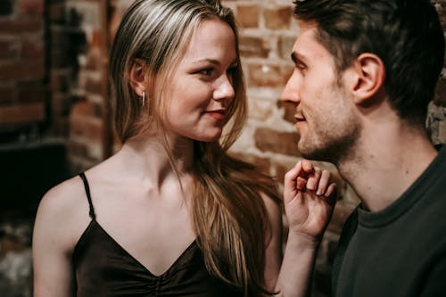 Free Young man and woman looking at each other enjoying romantic date together in cafe Stock Photo