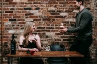 Couple celebrating birthday with cupcake in restaurant