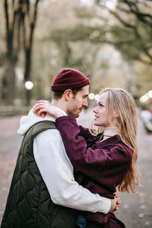 Free Couple standing in street while hugging near trees Stock Photo