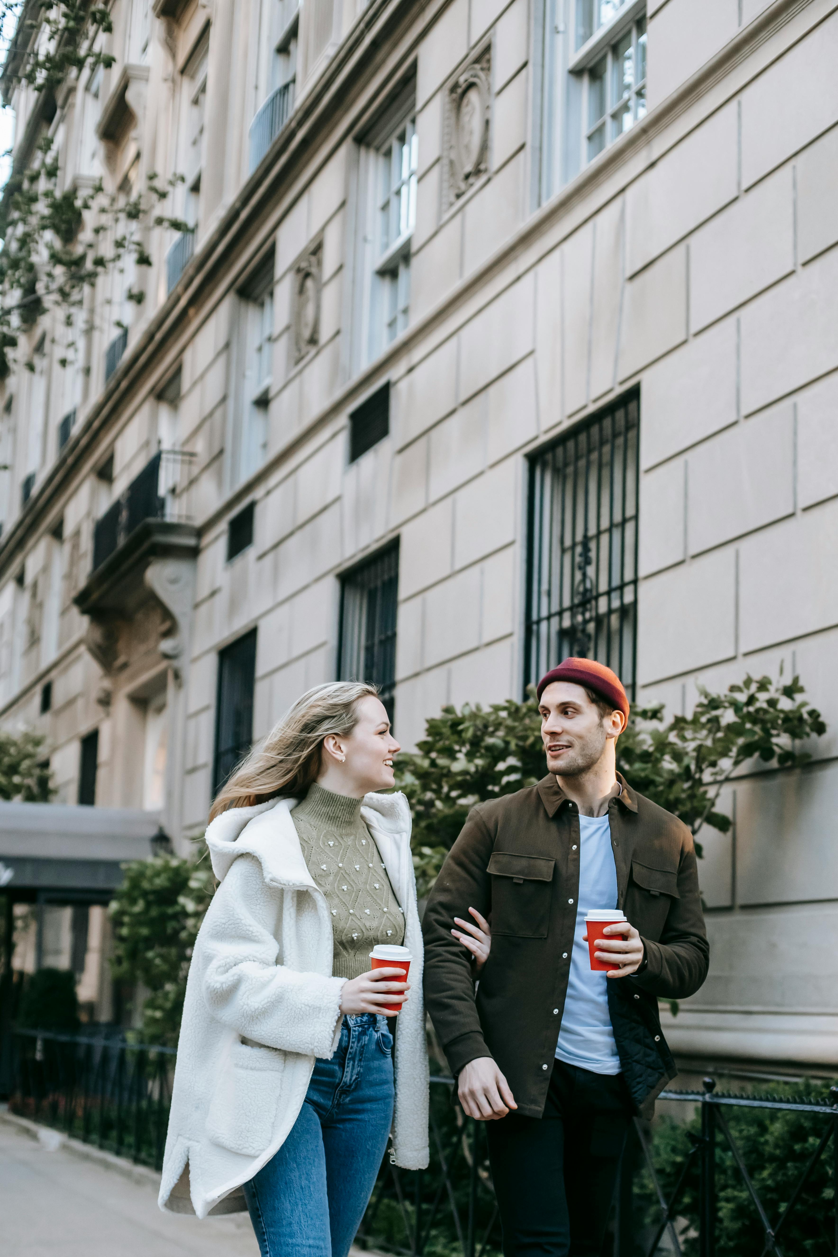 커피 컵과 함께 거리를 걷는 커플